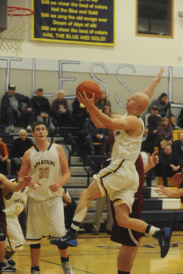 Spartan Colton Raben scores 2 of his 23 points  on this drive to the basket January 7th in Spartan Gym where Forks was defeated by Hoquiam 76 to 65.  Looking on is Spartan Marky Adams (32).