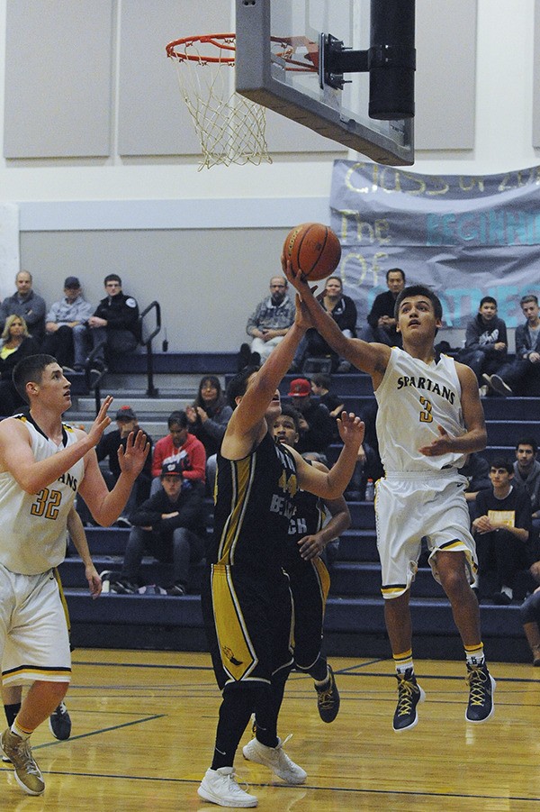 Spartan Keishaun Ramsey (3) drives to the basket against North Beach which defeated Forks in a run and gun contest 66-64. Following the play is Marky Adams (32).