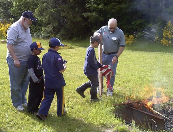Elks member Paul Hampton assists local scout with a proper flag retirement ceremony.