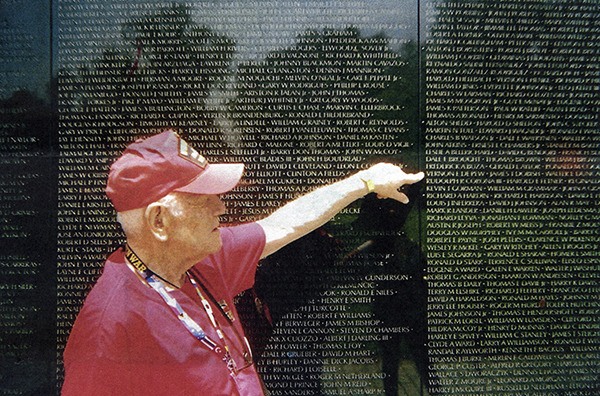 Robert Hall points out Vernon Depew's name on the Vietnam Memorial Wall.