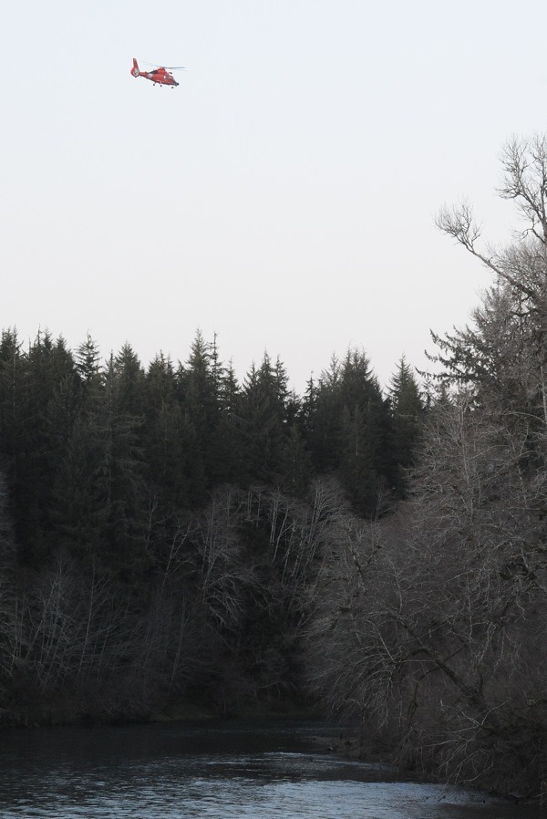 A USCG helicopter searches the Bogachiel River on Friday evening for the missing fisherman.