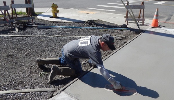 Moe Flores smoothes concrete before stamping mats are applied.