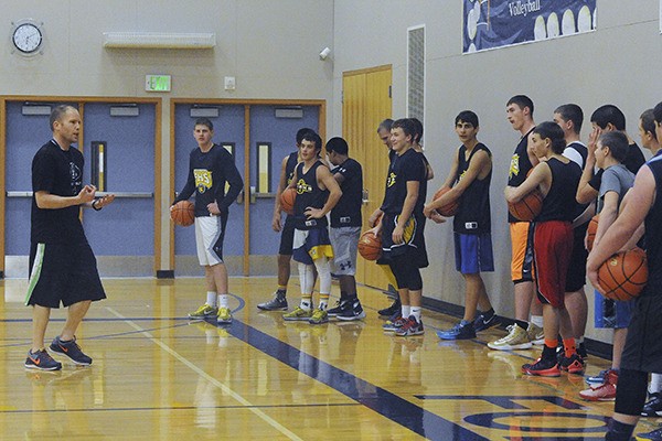 Boys varsity basketball coach Rick Gooding instructs players during Monday's opening practice.