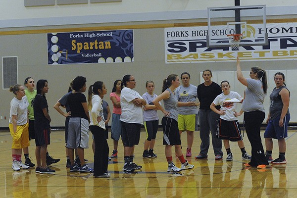 Varsity coach Madison Riebe (right) goes over procedures with this season’s girls basketball teams Monday during the first practice of the season.