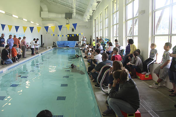 Spectators and fellow competitors watch on the right side of the pool as students operate their ROVs on the left side and two wet-suit-clad time keepers keep watch underwater at the Forks Athletic and Aquatic Club swimming pool. Cheers and applause rang out from the crowd as tasks were completed by the ROVs. Photo Christi Baron