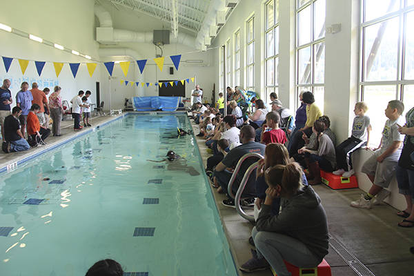Spectators and fellow competitors watch on the right side of the pool as students operate their ROVs on the left side and two wet-suit-clad time keepers keep watch underwater at the Forks Athletic and Aquatic Club swimming pool. Cheers and applause rang out from the crowd as tasks were completed by the ROVs. Photo Christi Baron