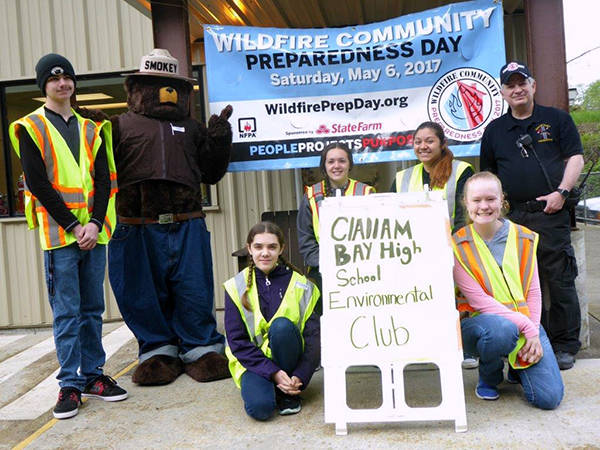Pictured are Michael Maines III, Kalin Duncan (Smokey Bear), Victoria Donoghue, Chelsey Ritter, Kathleen Gonzalez, Rosie Cain, and Captain Rausch; photo by Mrs. Mowrer (adviser). Refreshments were provided by the Environmental Club and the paper supplies were donated by Sunset Co-op of Clallam Bay. Submitted Photo