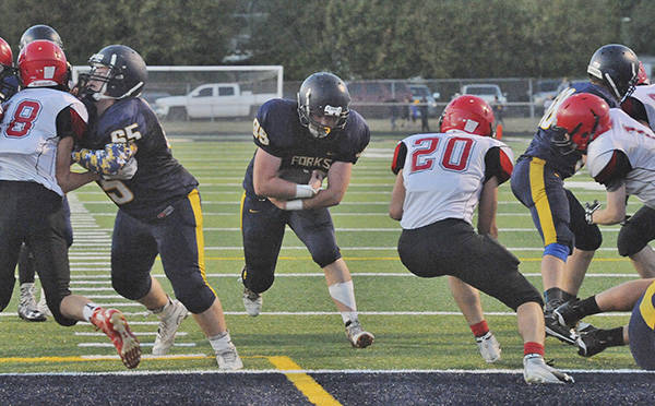 Spartan Running back Caleb Peters finds a hole behind the blocking of Corbin Baker (65) and Shane Queen (68) during homecoming as Forks defeated Neah Bay 50 to 0. Next up is Montesano at Forks. Photo by Lonnie Archibald