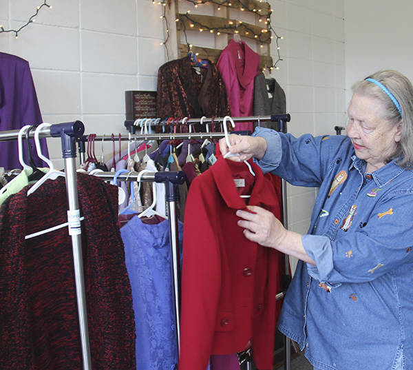 Soroptimist volunteer Vicki Andros looks over one of the many items available for sale at the Second Chances store the club operates on Spartan Avenue. Photo Christi Baron