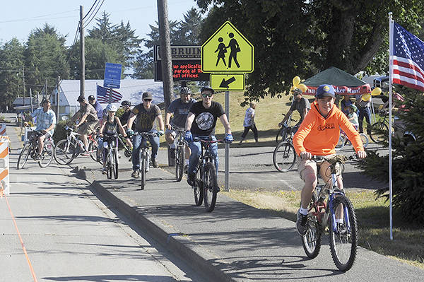Bicyclists leave the Clallam Bay School entrance during the annual Poker Ride Race.