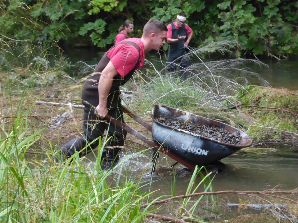 OCC inmate crew member places a wheelbarrow full of gravel in the creek. Photos David Hahn