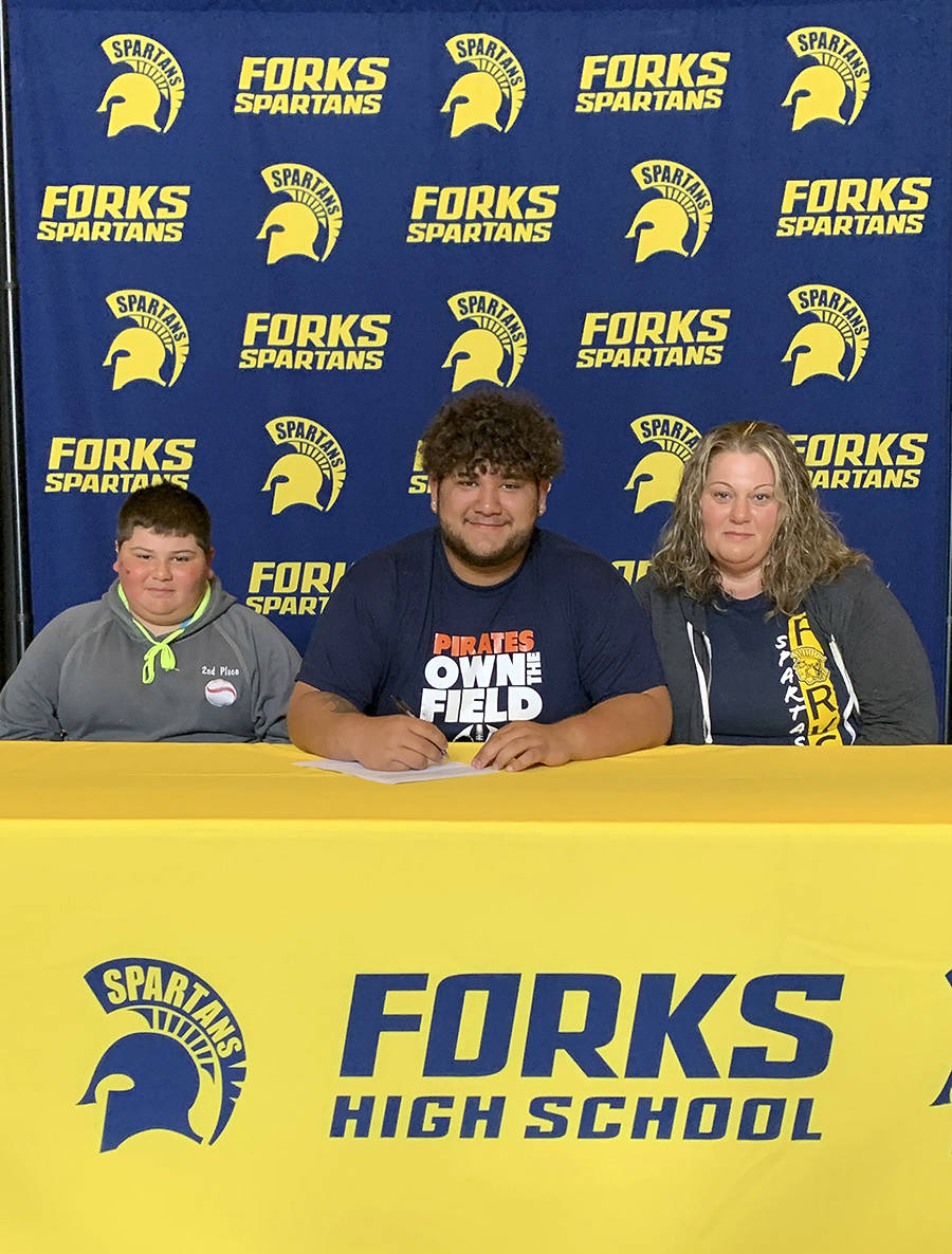 Forks Spartan Iziah Morton signs and is joined by younger brother Daniel Ferreyra and his mother Tauna Morton. Submitted Photo