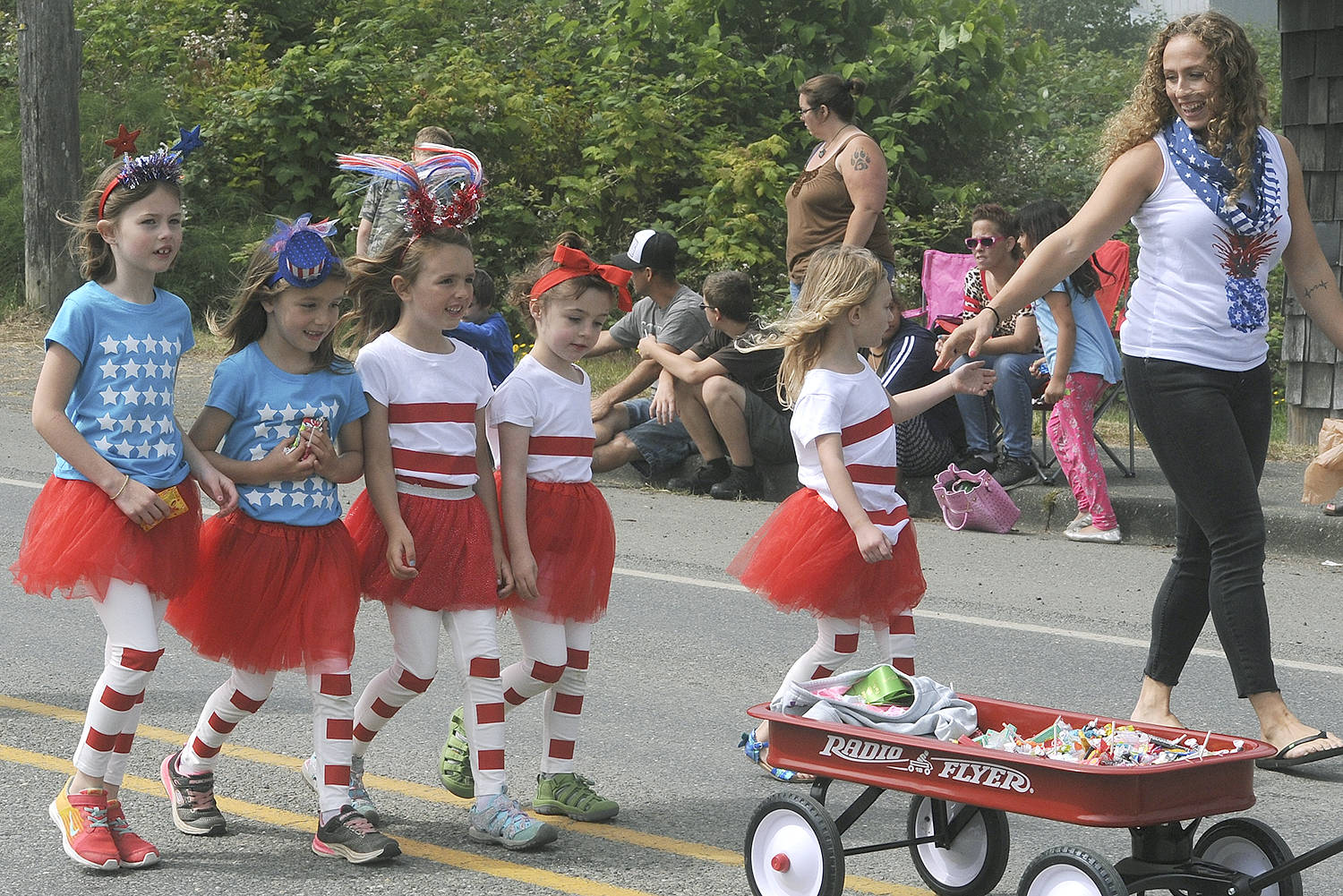 Salute! they are a walking US Flag! The American Girls, sponsored by the Parlor Café of Forks, walk the parade route with a wagon full of candy. Standing together the American Flag is revealed. Photos by Lonnie Archibald