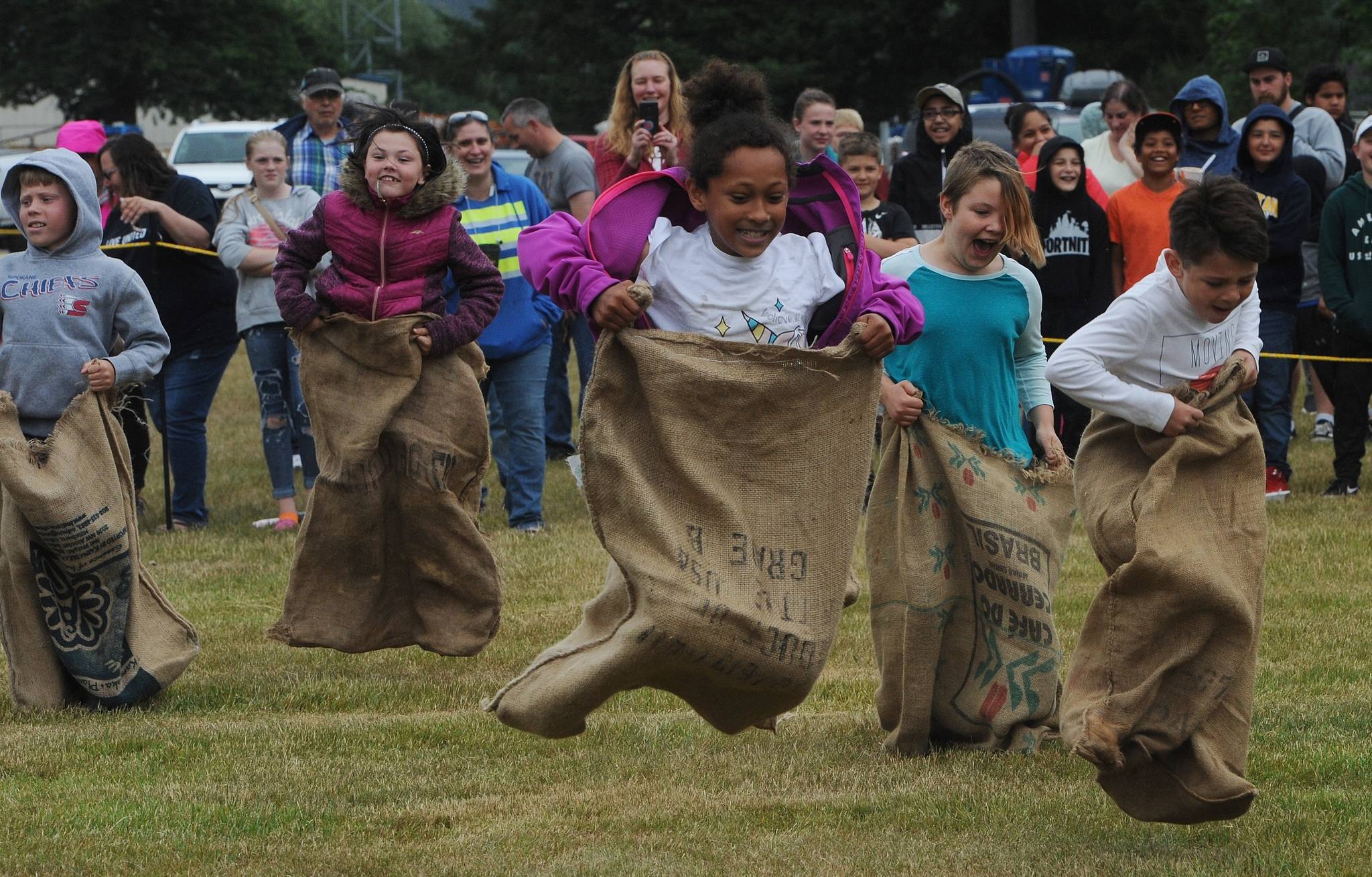 The 9 and 10-year-olds compete in the gunny sack races. Photo by Lonnie Archibald