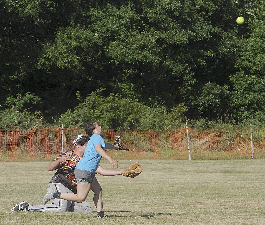 Forks Nids fielders Ken Daman and Spartan State Softball participant Aspen Rondeau run for a fly ball which was caught by Daman in a leaping catch as the Nids defeated the Red Dogs of Lady Smith, Vancouver Canada.