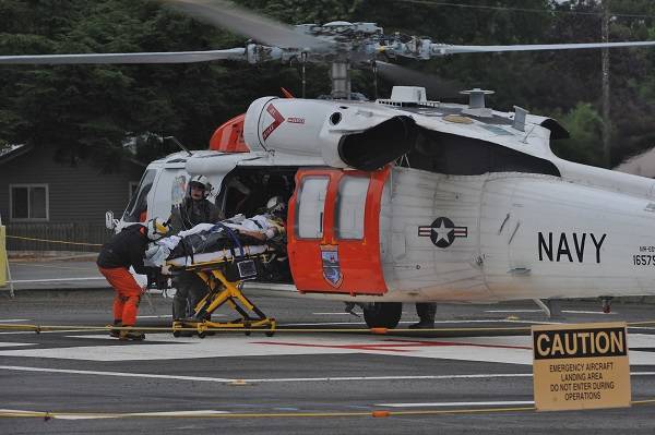 Injured logger, Terry Tyler, was airlifted Friday morning August 16 from the Forks Hospital by Navy helicopter to Harborview in Seattle. Photo by Lonnie Archibald