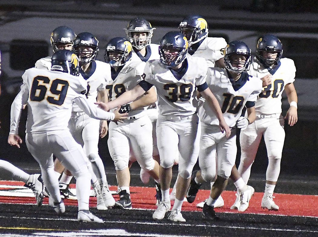 Members of the Forks football team gather around Hayden Queen (38) following his defensive touchdown early in the first quarter on Saturday against Tenino. It was his first of three touchdowns during the Evergreen 1A League game. Forks had plenty to celebrate during their 45-13 win on Saturday in Tenino.