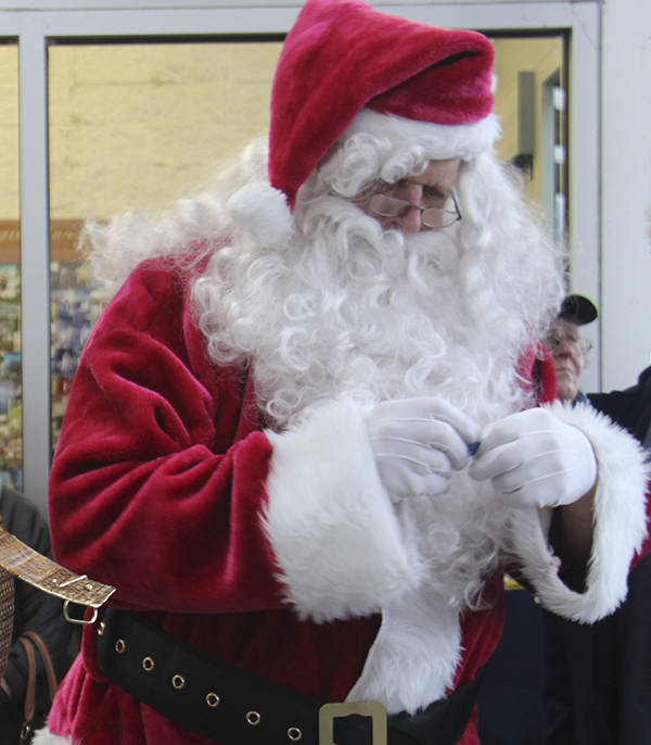 One of Santa’s many stops Saturday was the WEBPA Santa bucks Drawing outside Forks Outfitters. Here he reads one of the names of a lucky winner. Photo Christi Baron