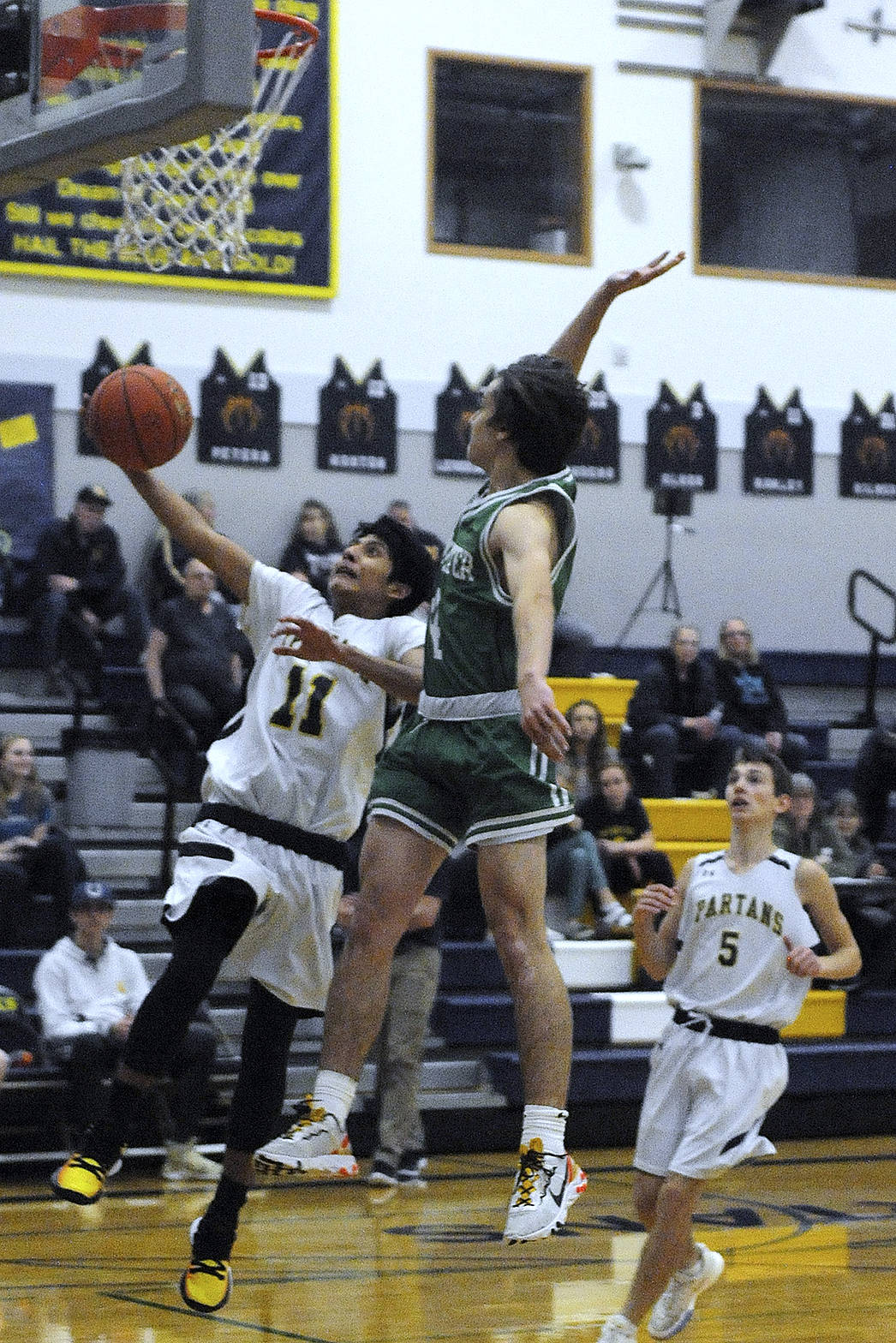 JV player Jonathan Jackson-Cruz (11) puts up a shot while Ashton Doyle (5) trails the play.