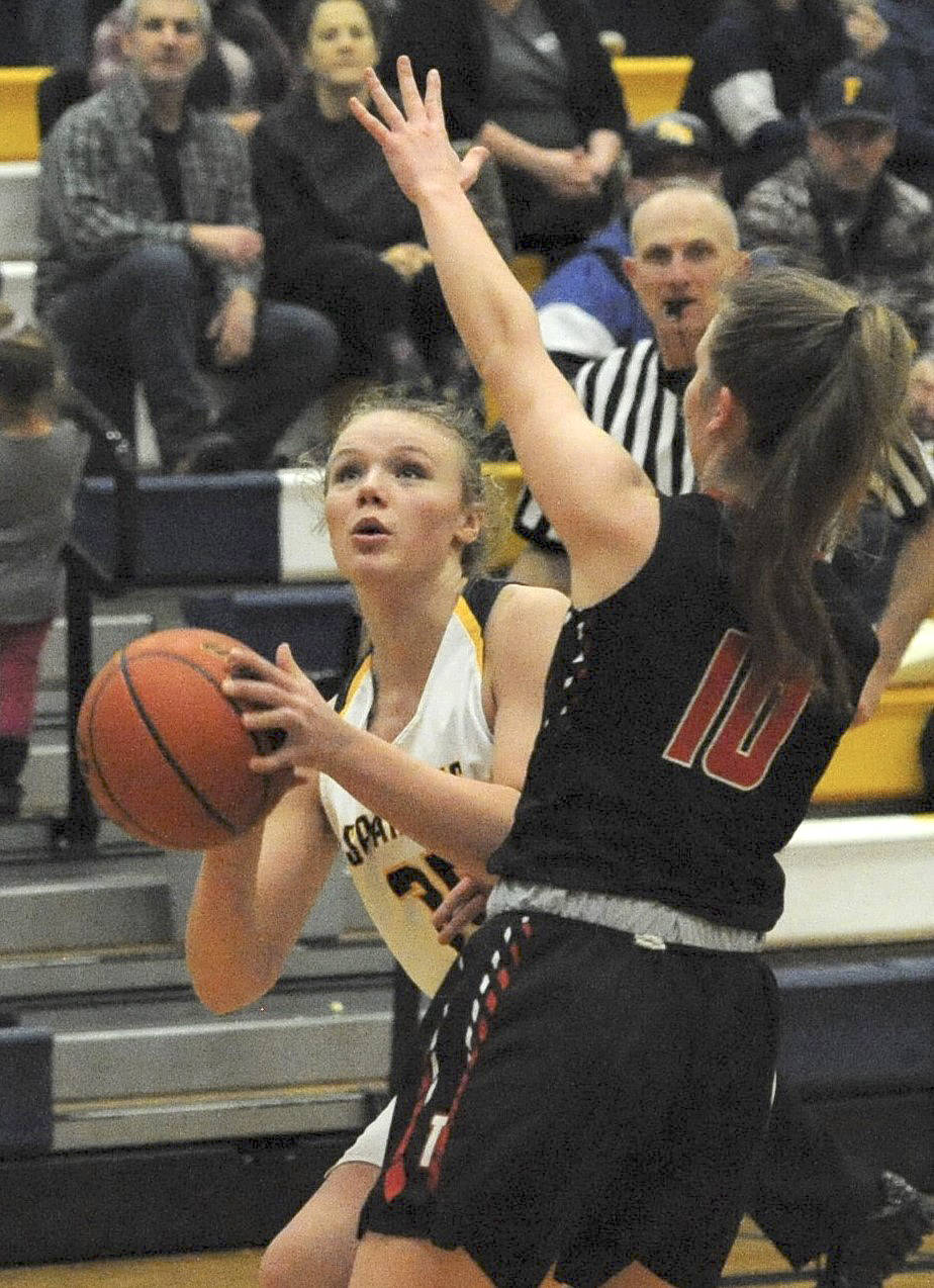 At right, Spartan Kyra Neel eyes the basket against Tenino’s Grace Vestal Jan. 7 in Forks where the Beavers defeated the Spartans 45-27 in this league contest. Photo by Lonnie Archibald