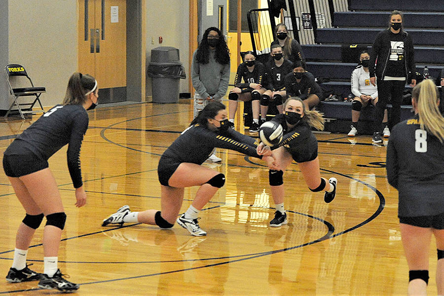Kaidence Rigby and Colbie Rancourt hit while teammate Kray Horton looks on. Forks defeated Rainier 3-0 in the Spartan Gym. Photo by Lonnie Archibald