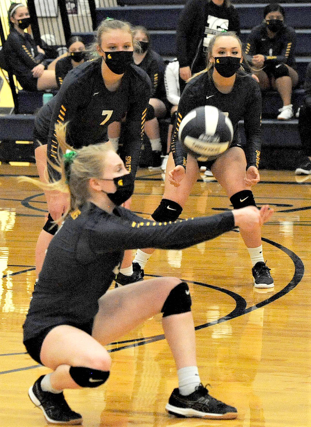 Forks’ Kadie Wood hits while Kyra Neel (7) and Colbie Rancourt look on. Photo by Lonnie Archibald