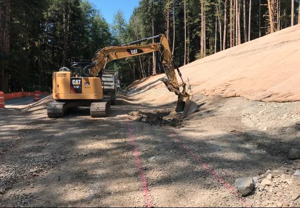 Finishing the slope and establishing the ditch-line for the new alignment of the road approaching the Canyon Creek bridge. Photos FHWA