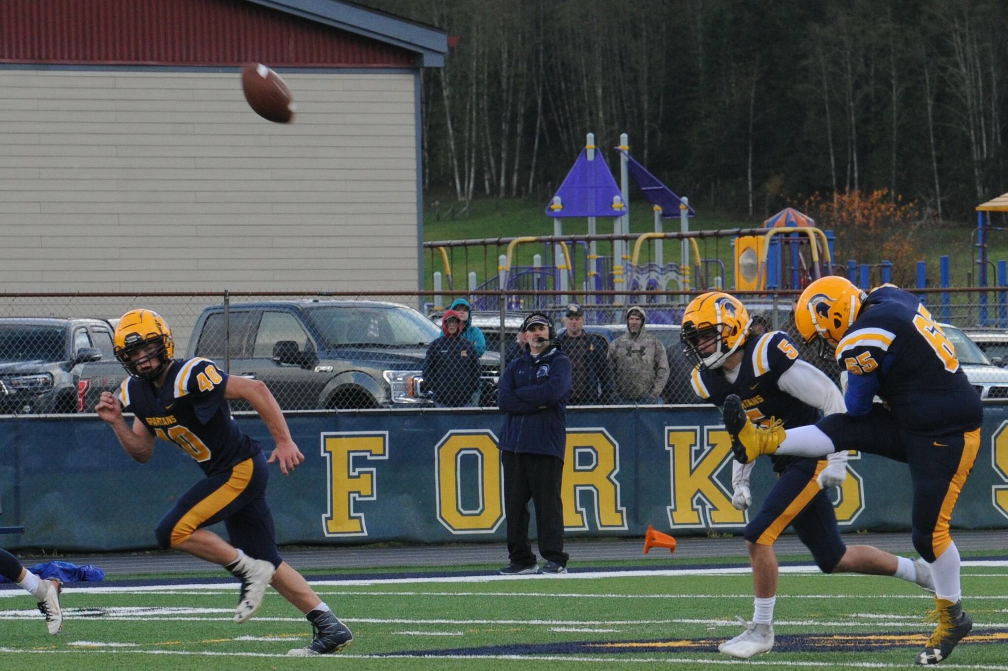 Forks head coach Trevor Highfield looks on while Spartan kicker Hector Dominguez kicks the ball into the endzone.  Also in the action are Nate Dahlgren (40) and Landon Davis (5).  Photo by Lonnie Archibald