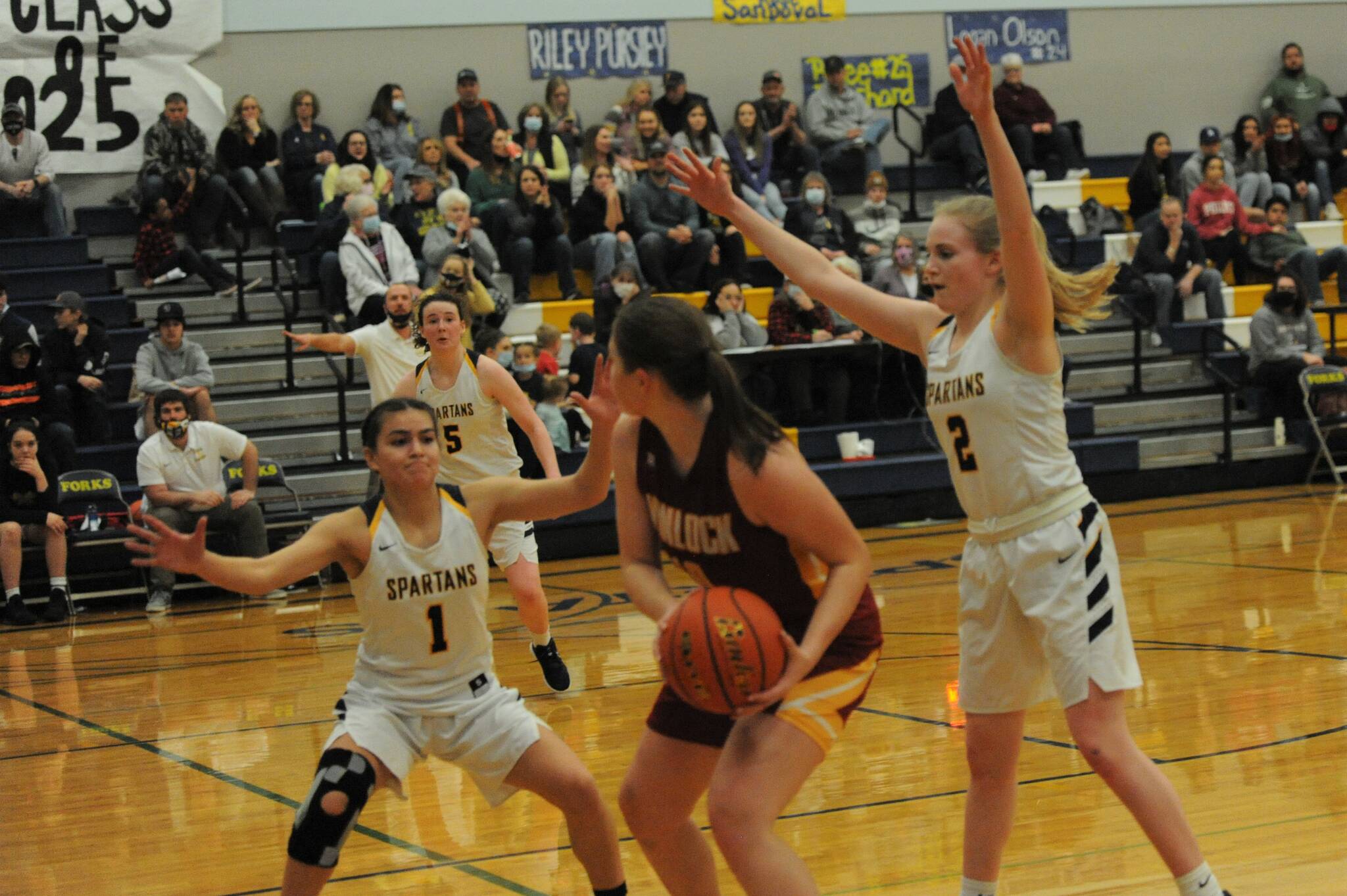 On the defense for Forks are Candida-Rose Sandoval (1) and Kadie Wood (2) against the Winlock Cardinal in this District Four playoff held in the Spartan gym on Saturday, Feb 5. Looking on is Forks Keira Johnson (5). Forks defeated Winlock 59 to 55 to earn advancement in the winner’s bracket. Photo by Lonnie Archibald