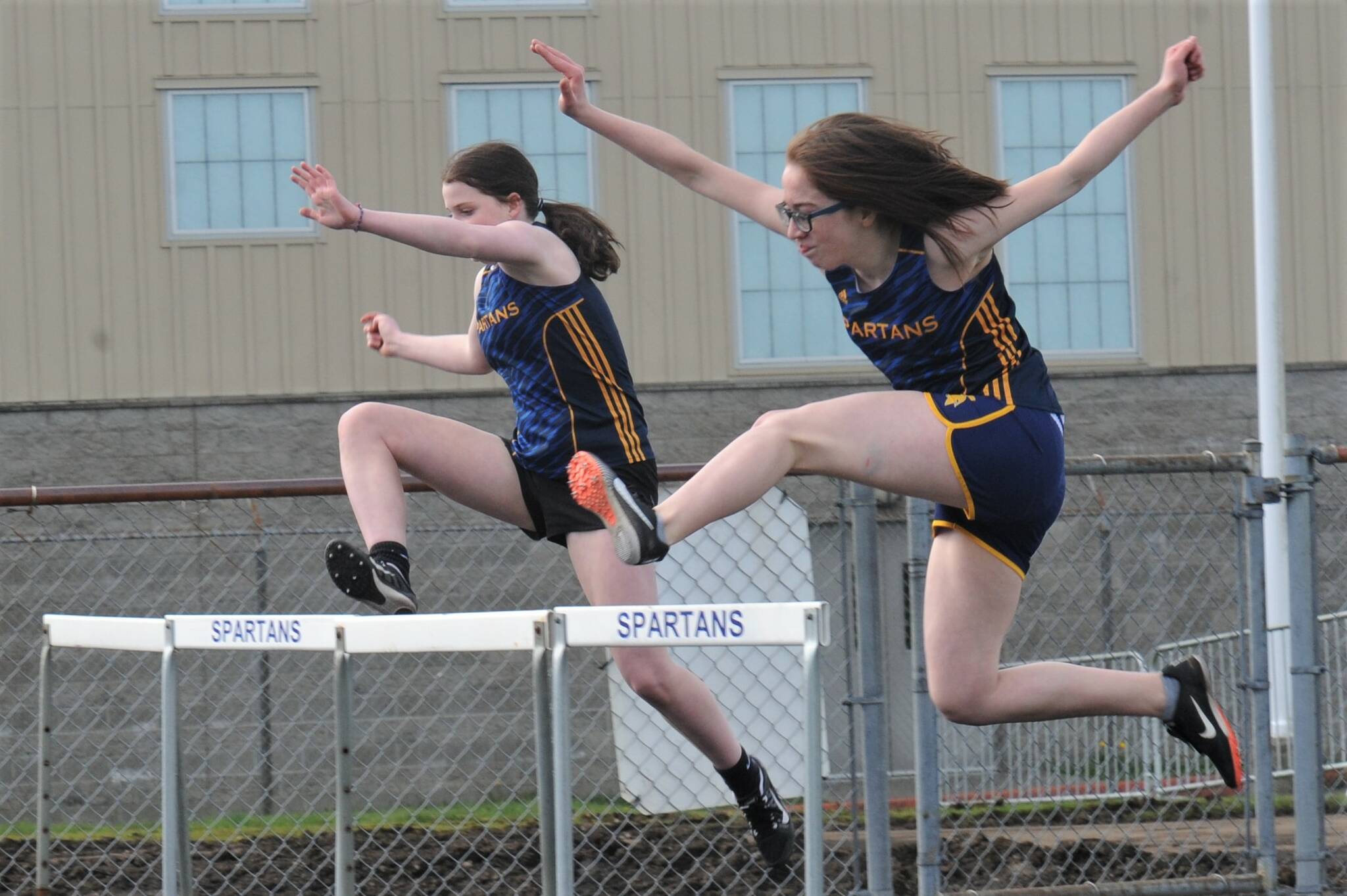 Forks’ Payton Johnson (left) and Flora Horejsi competed in the 100 hurdles. Photo by Lonnie Archibald