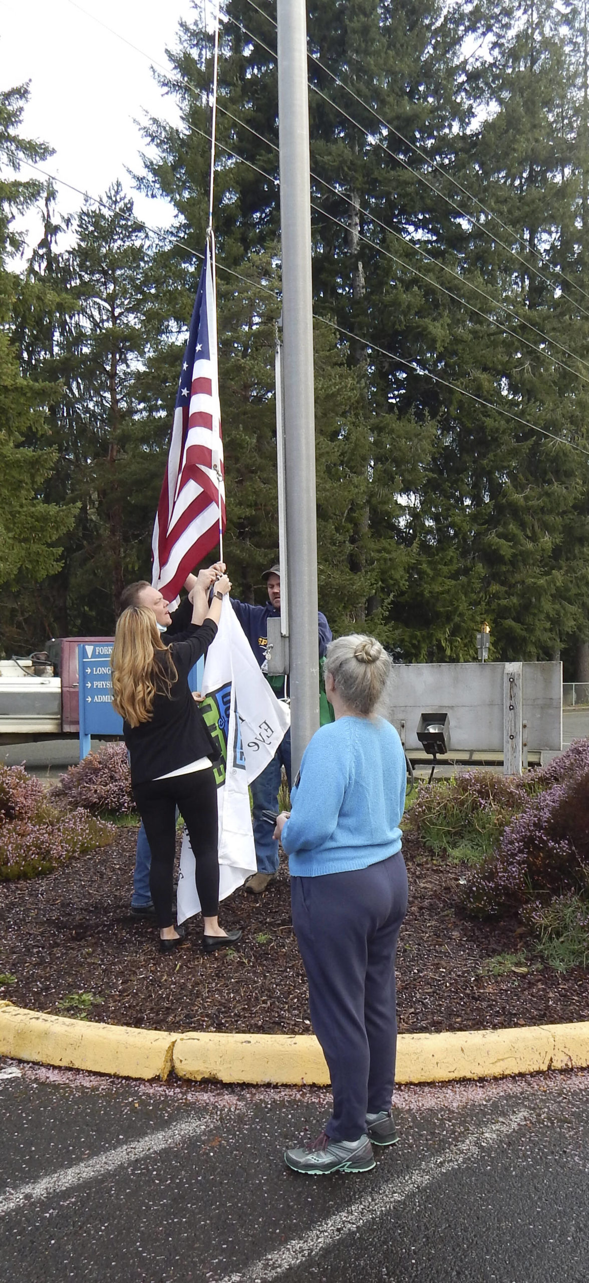 Deborah Dillon looks on as the Flag was raised by Eric Anderson, Kelly Thompson, and Jason Dabney. Photos Christi Baron