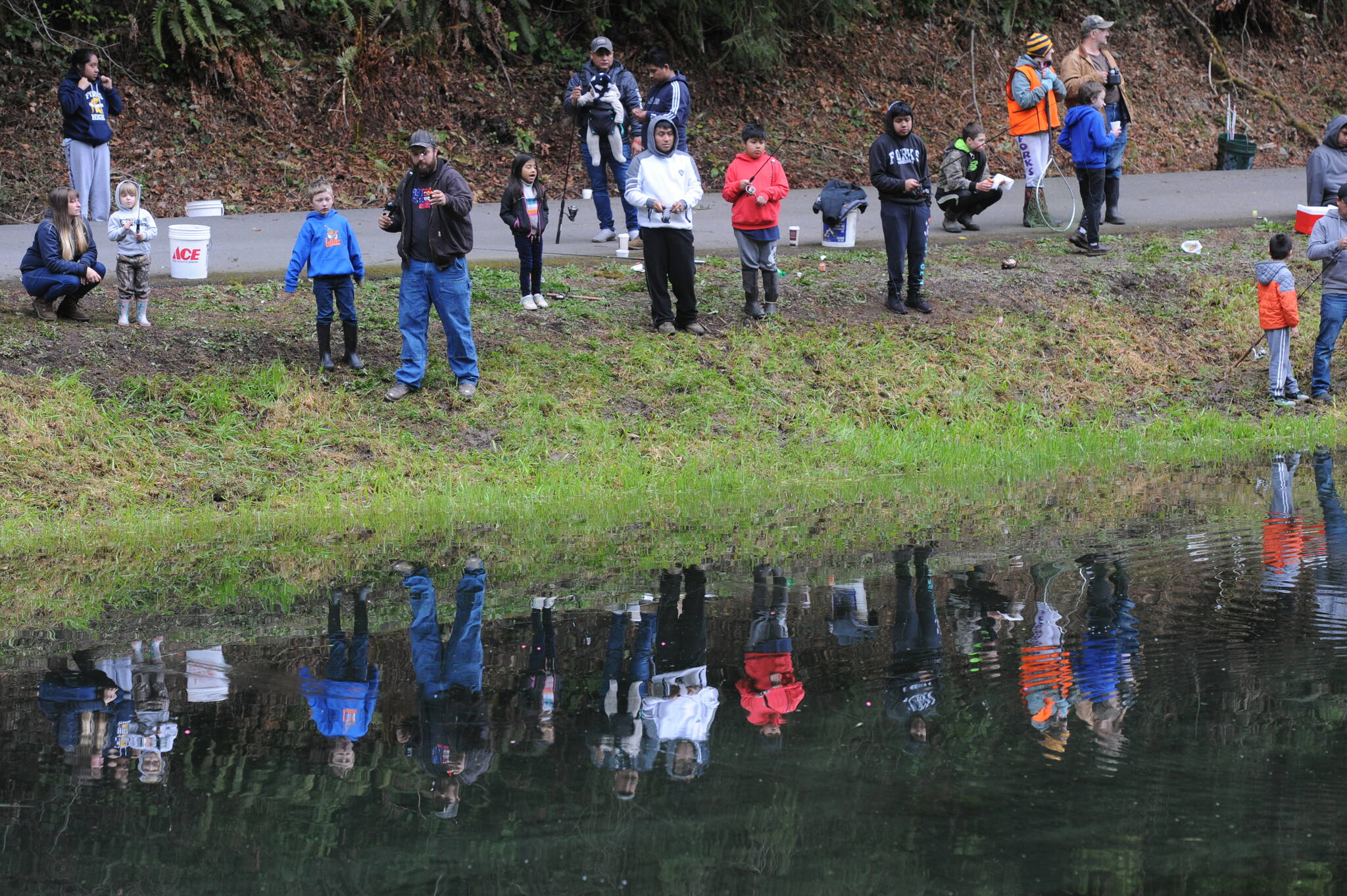 Fishermen were reflected in the pond on this overcast Kids Fishing Day …without rain.