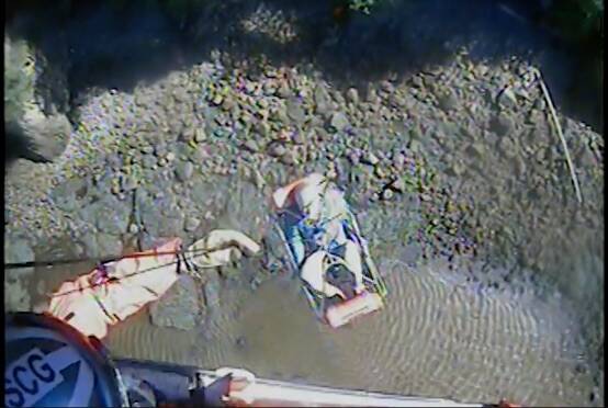 Photo from video - An Air Station Port Angeles aircrew medevacs an injured 73-year-old hiker from the beach near Cape Johnson in Olympic National Park. (U.S. Coast Guard video by Petty Officer 3rd Class Michael Clark)