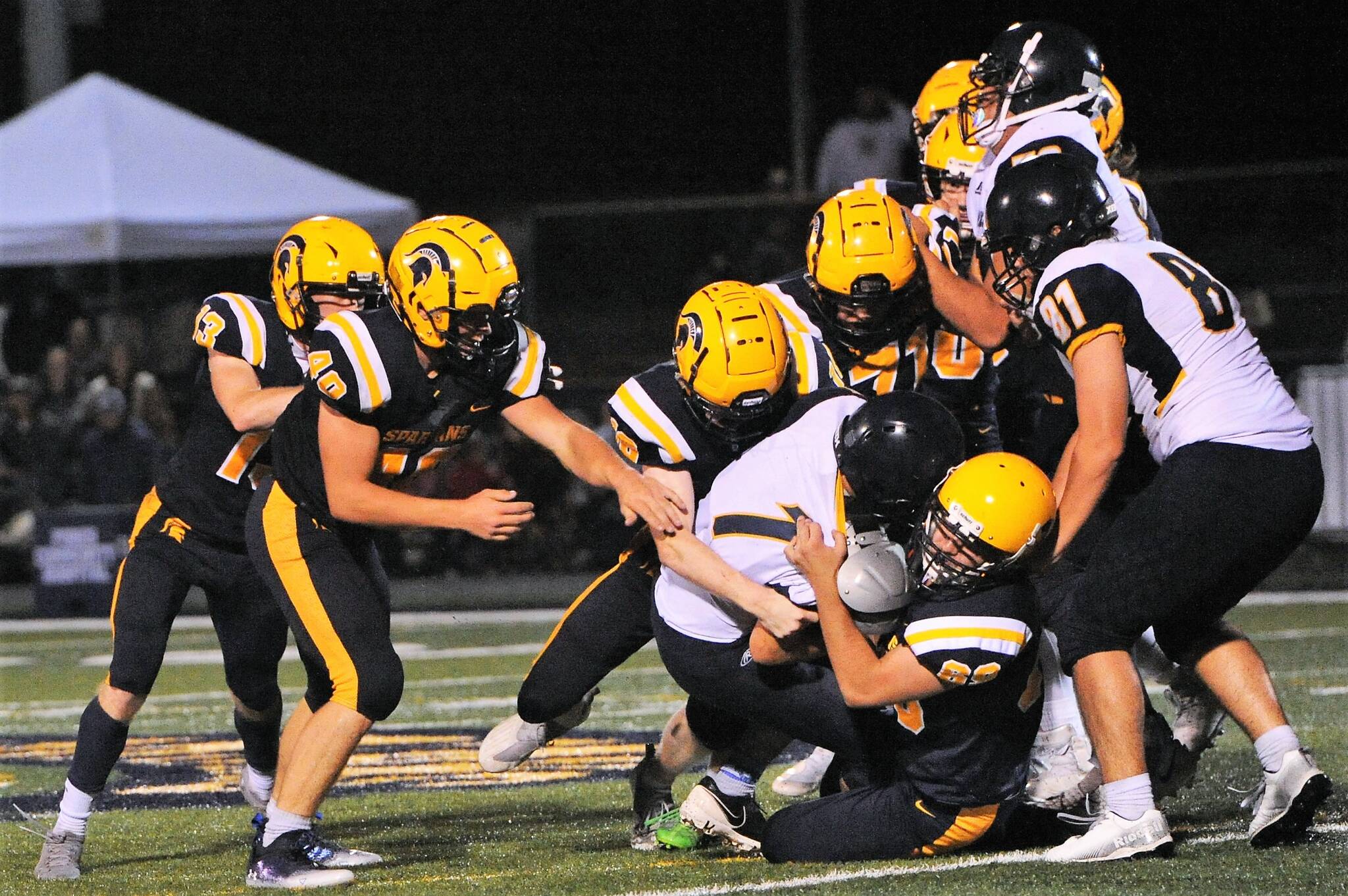 The Spartan defense was outstanding as was the defense pictured here on this gang tackle as Forks took a 49 to 0 halftime lead. Photo by Lonnie Archibald