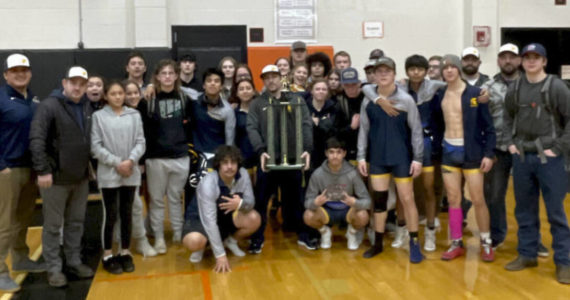 The Forks boys wrestling team celebrates its first-place trophy at the Rainier Duals Tournament. (Forks wrestling)