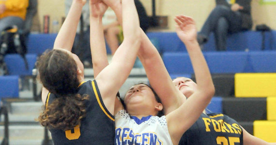 Crescent’s Ciara Cargo-Acosta, center, reaches for a rebound and is squeezed by Forks’ Keira Johnson, left, and Kyra Neel during Wednesday’s game at Crescent High School. (Keith Thorpe/Peninsula Daily News)