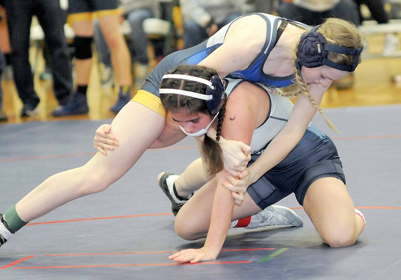 Forks’ Miley Blanton, top, takes on Grace Odun of River Ridge in the 119-pound class on Saturday at Port Angeles High School. (Keith Thorpe/Peninsula Daily News)