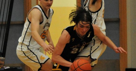 Spartan’s Landen Olson (left) and Dylan Micheau defend against North Beach’s Kobe Charley in this league contest won by Forks 58 to 21. Photo by Lonnie Archibald