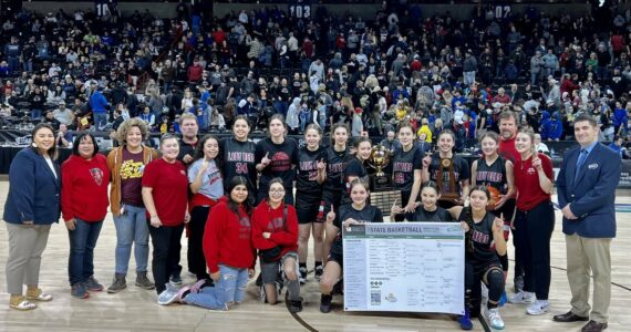 The Neah Bay girls basketball team celebrates winning the 1B state championship Saturday night in Spokane. (Bridget Mayfield/for the Peninsula Daily News)