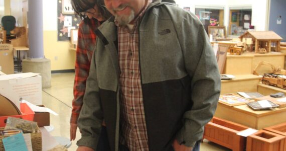 On Sunday, Gina Chaney and Forks Mayor Tim Fletcher look over items awaiting their time to be up for bid. Photo Christi Baron