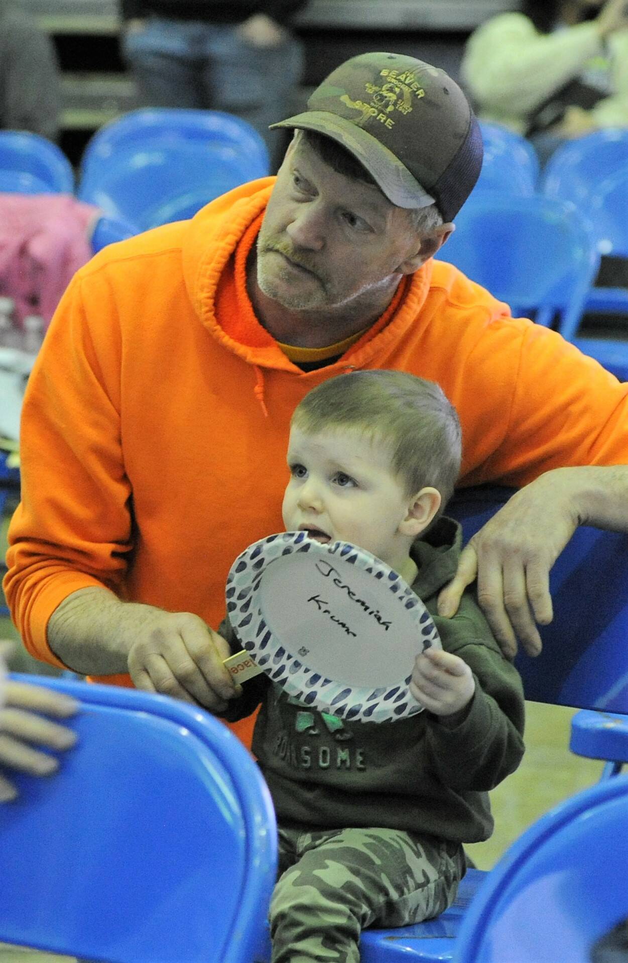 With the help of Andy Krume, two-year-old Jeremiah Krume makes his bid at the scholarship auction Saturday. Photo by Lonnie Archibald