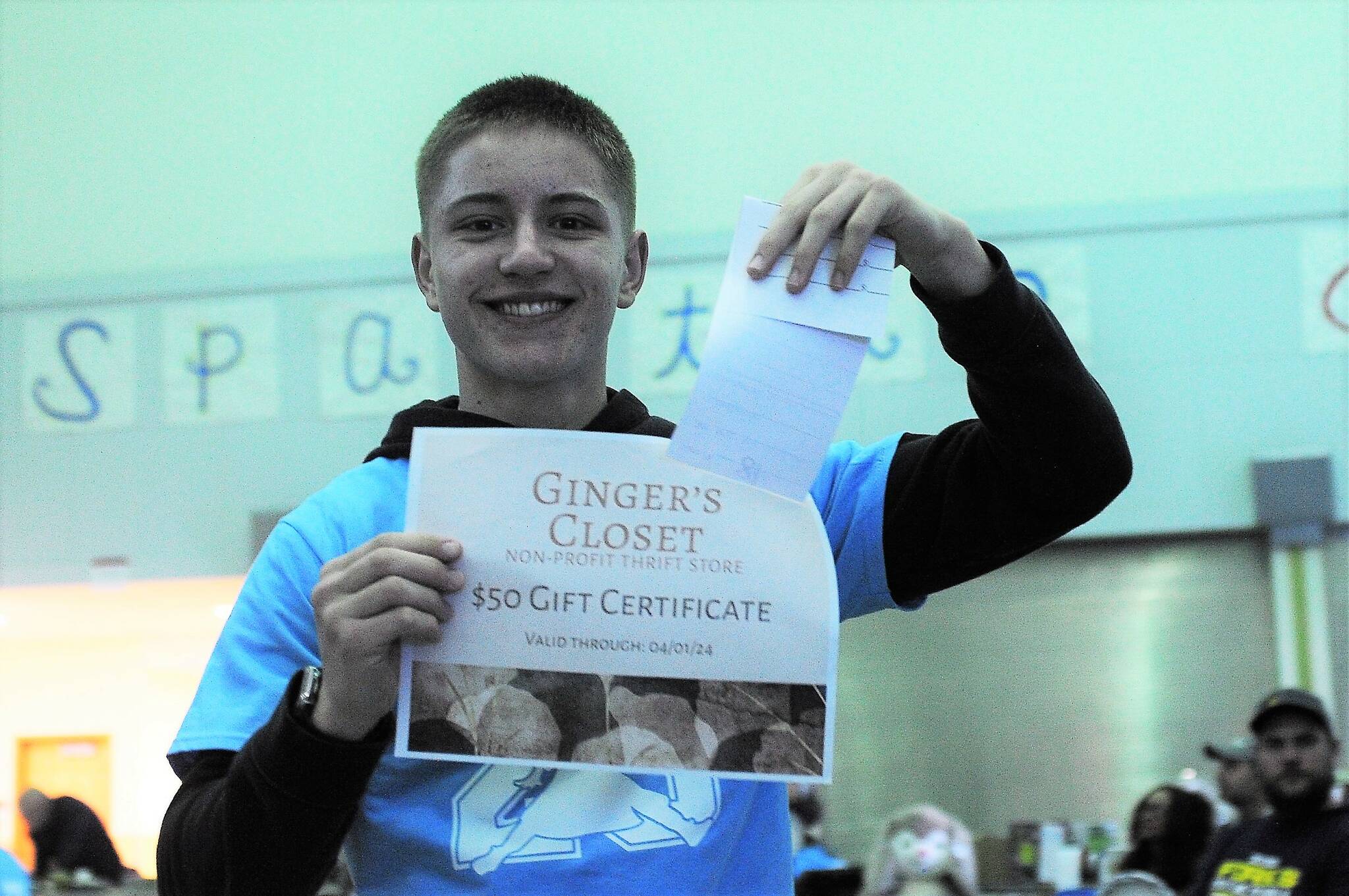Senior Klayton Helvey displays a $50 gift certificate for Ginger’s Closet. Photo by Lonnie Archibald