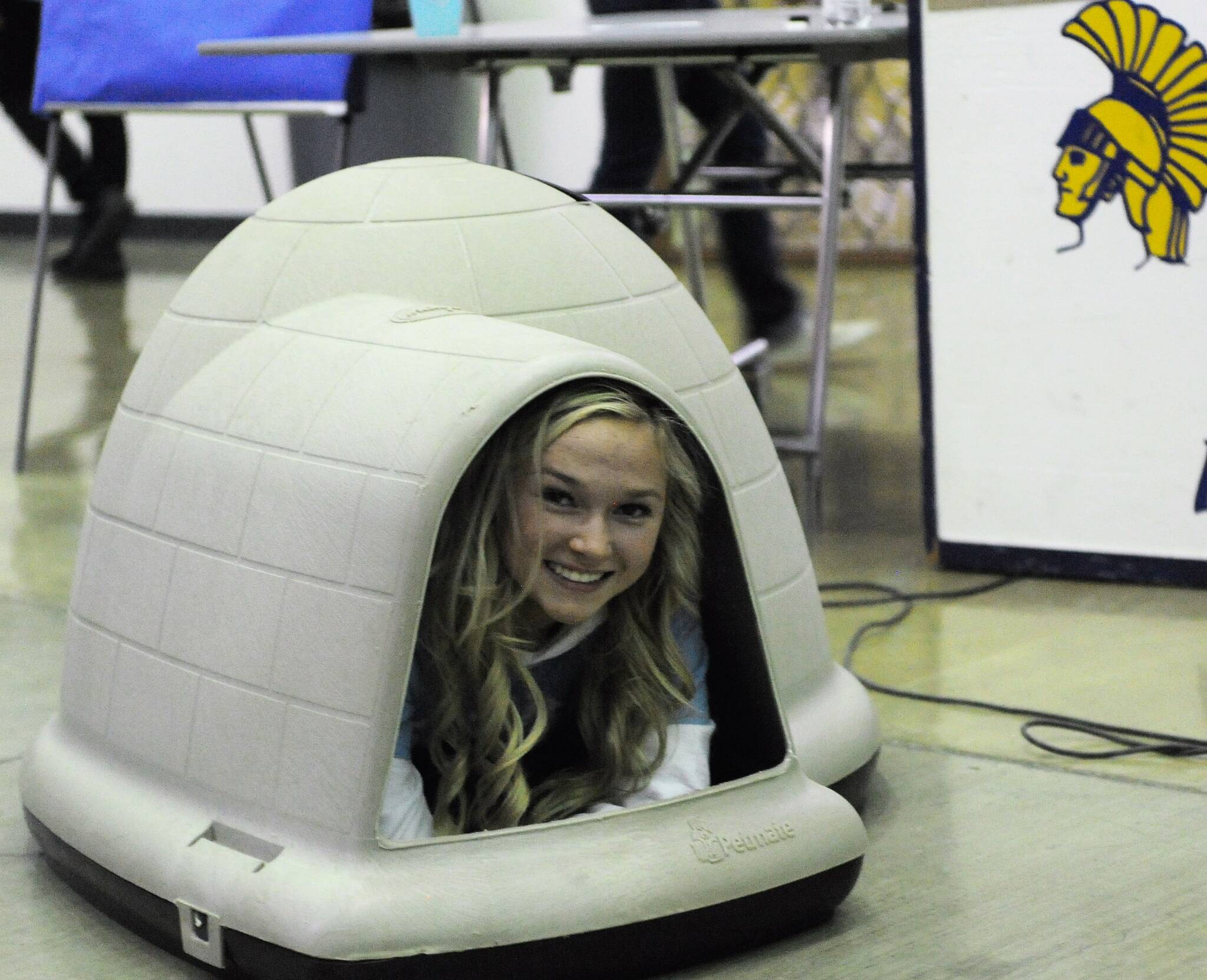 Forks senior Zoie Davis demonstrates a dog house up for bid Sunday during the Quillayute Valley Scholarship Auction. Photo by Lonnie Archibald