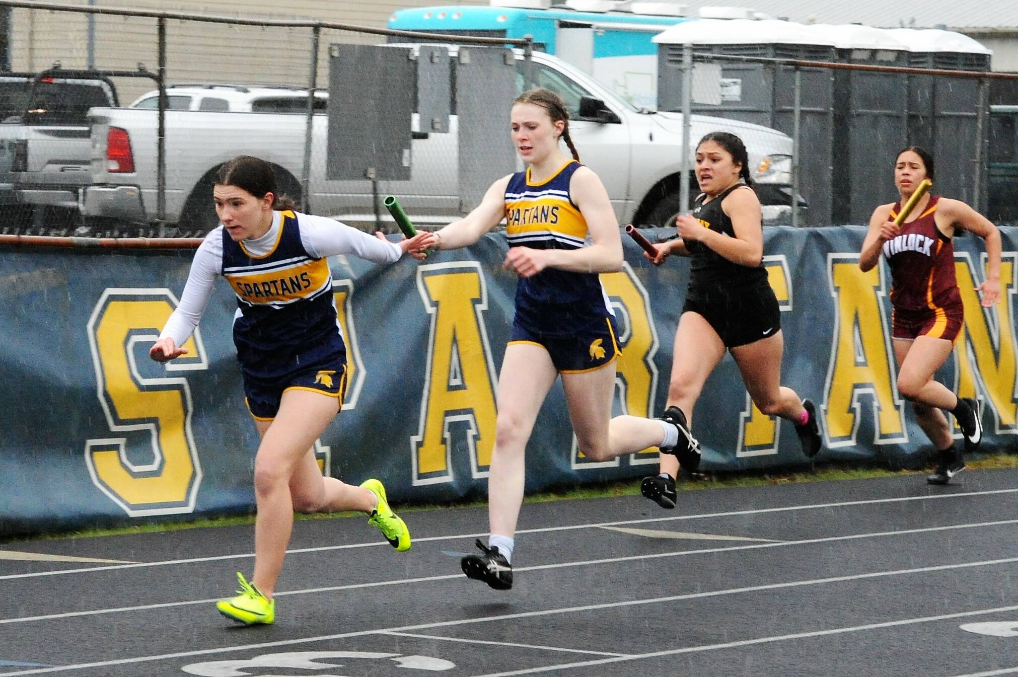 Miley Blanton passes the baton to Erika Williams in the relay. Photo by Lonnie Archibald.