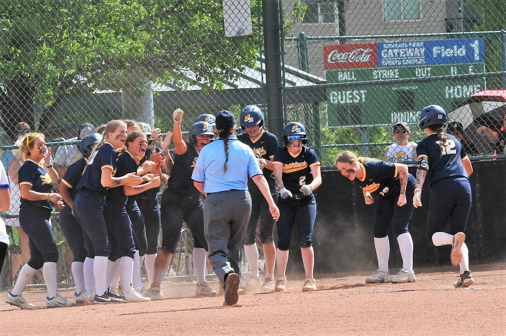 Spartan teammates greet Chloe Gaydesk-St. John at home plate after her home run against Warden Friday during the State 2B softball championships. Photo by Lonnie Archibald