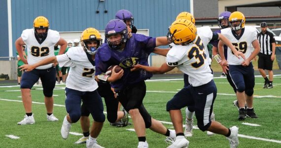 Spartans Kenneth Daman (92), Noah Foster (2), Carter Tossie (35), and John Parker Jr (69) converge on this Sequim running back. Photo by Lonnie Archibald