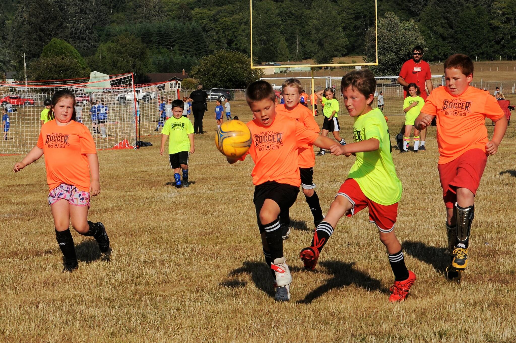 Pictured here in the 7 to 9 age bracket the Tigers in orange and the Yellow Bananas in yellow, and that makes sense, hustle for ball control. Perhaps these future Spartans are getting a good jump on what could come a few years down the road as they just might compete in the 2B Pacific Soccer League. As for now, however, they enjoy competing against classmates in a friendly atmosphere. And yes, thanks to the many volunteers, these kids are getting a real kick out of soccer.