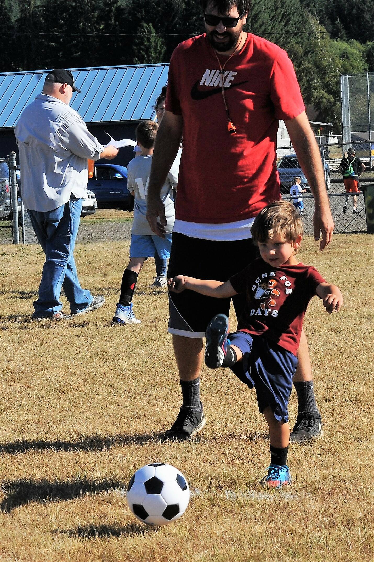 Four-year-old Hudson Weekes appears to be on target while father Keith looks on.