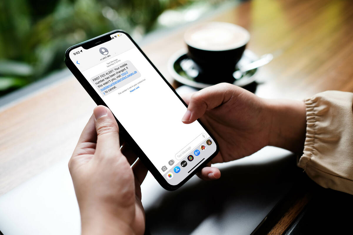 Woman sitting and holding blank screen mock up mobile phone with coffee cup at cafe.