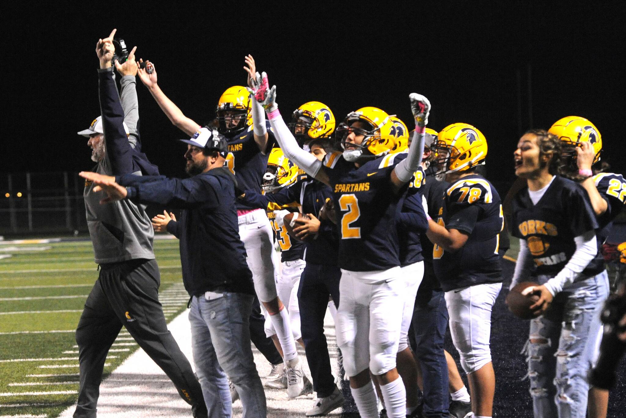Forks coaches and players begin to celebrate their win over the Titans 21 to 18 Friday night on the turf of Spartan Stadium. Photo by Lonnie Archibald
